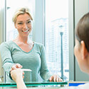 woman taking card from front desk worker