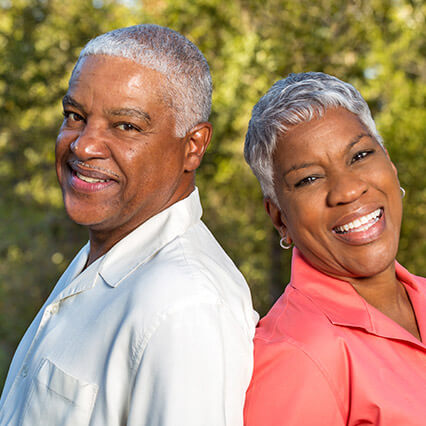 husband and wife smiling outside